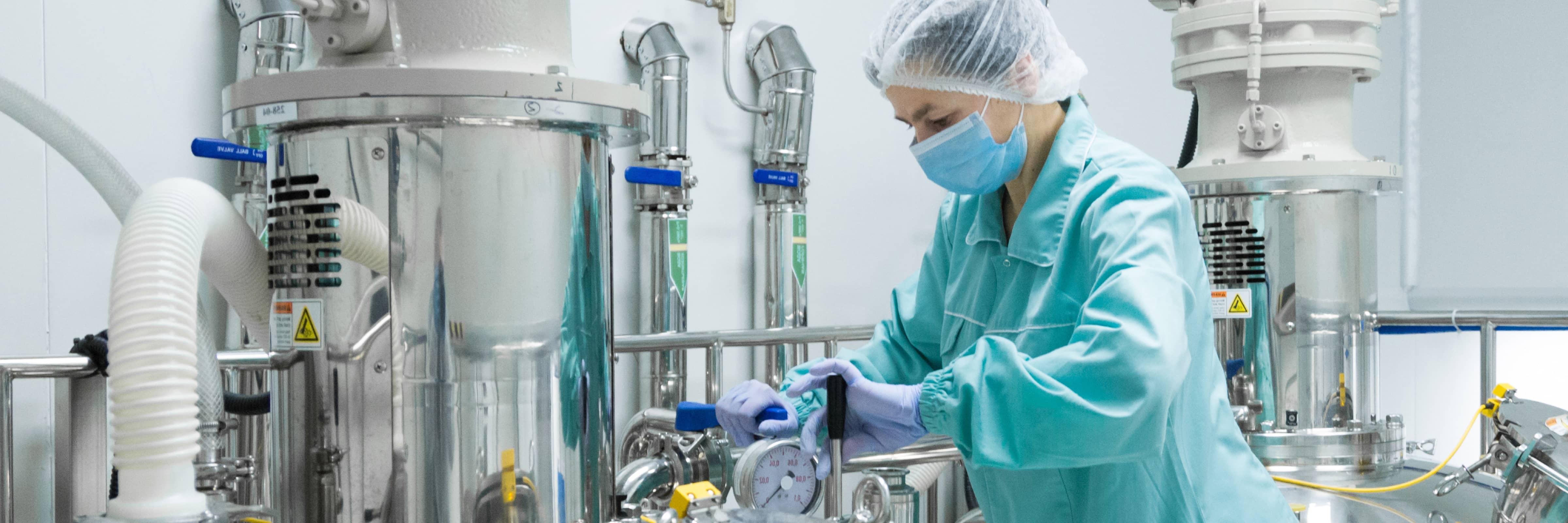 Worker at a pharmaceutical manufacturing facility operating a machine