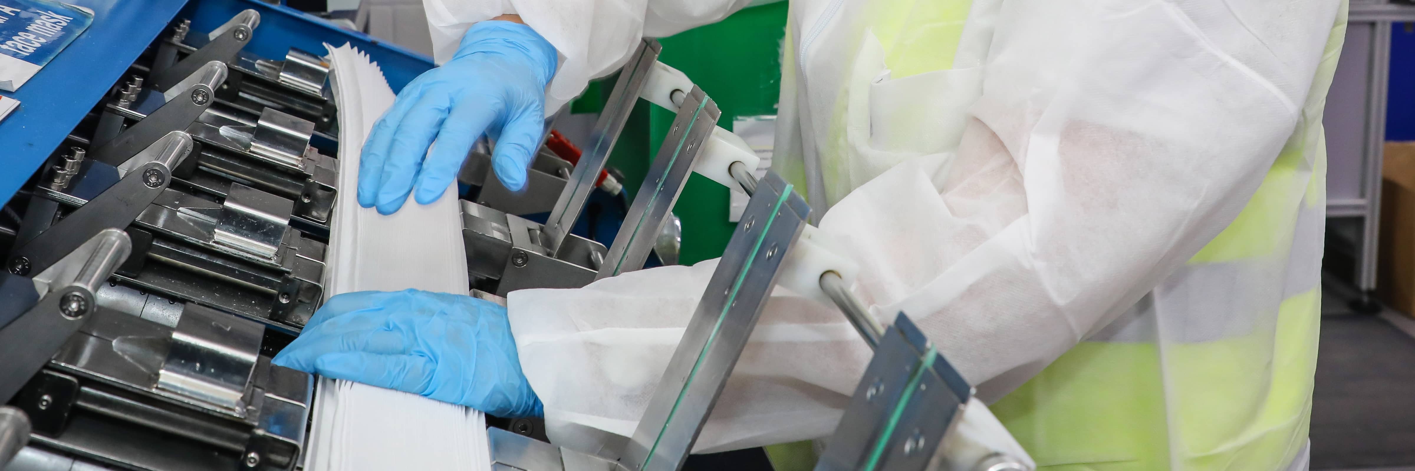 Worker at a coatings manufacturing plant operating a machine