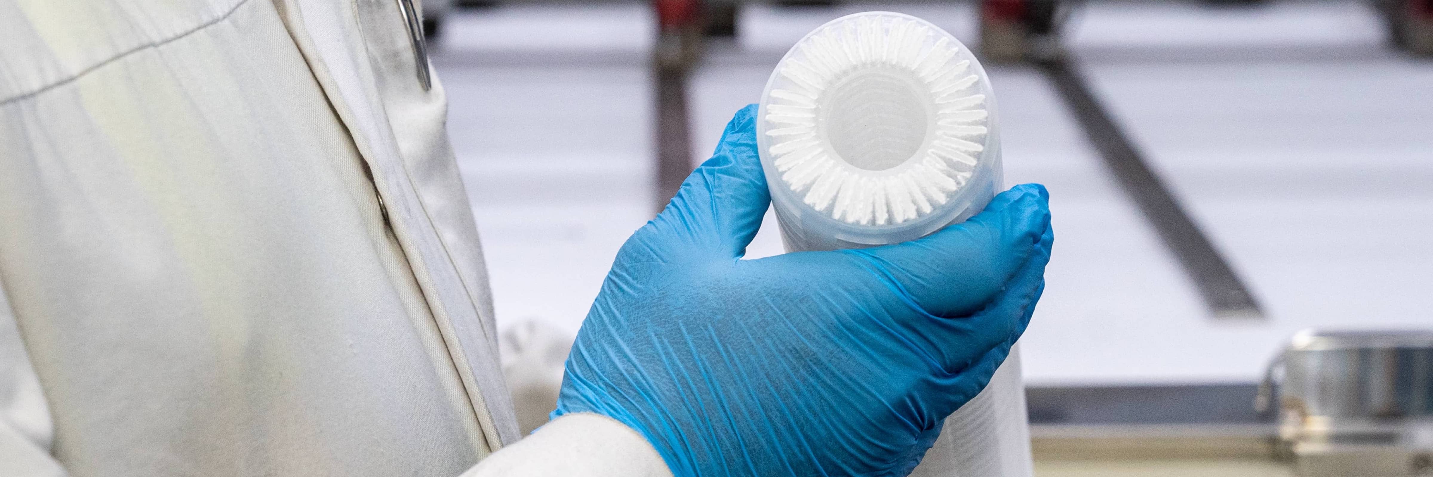 Worker at a filter manufacturing plant examining a filter