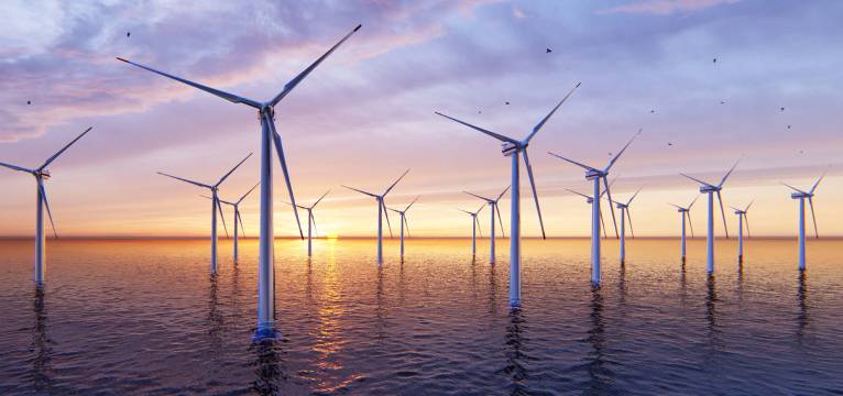 Offshore windfarm, comprised of multiple turbines, seen at twilight