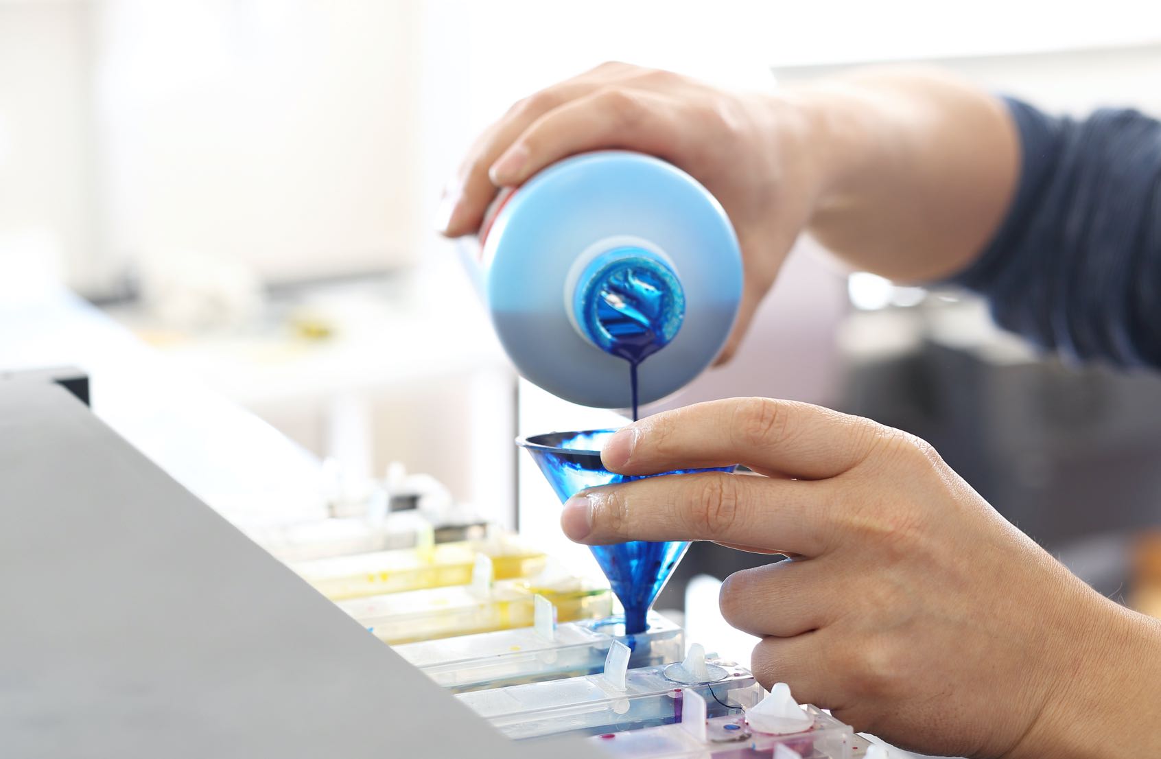 operator pouring ink into containers