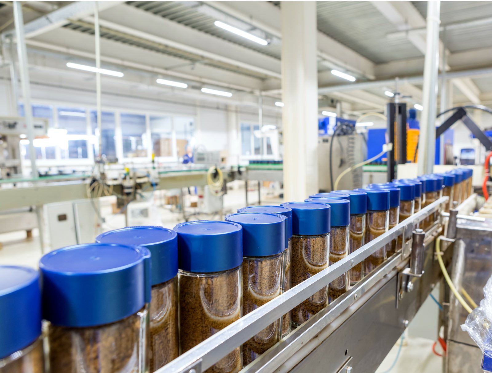 instant coffee containers over conveyor belt