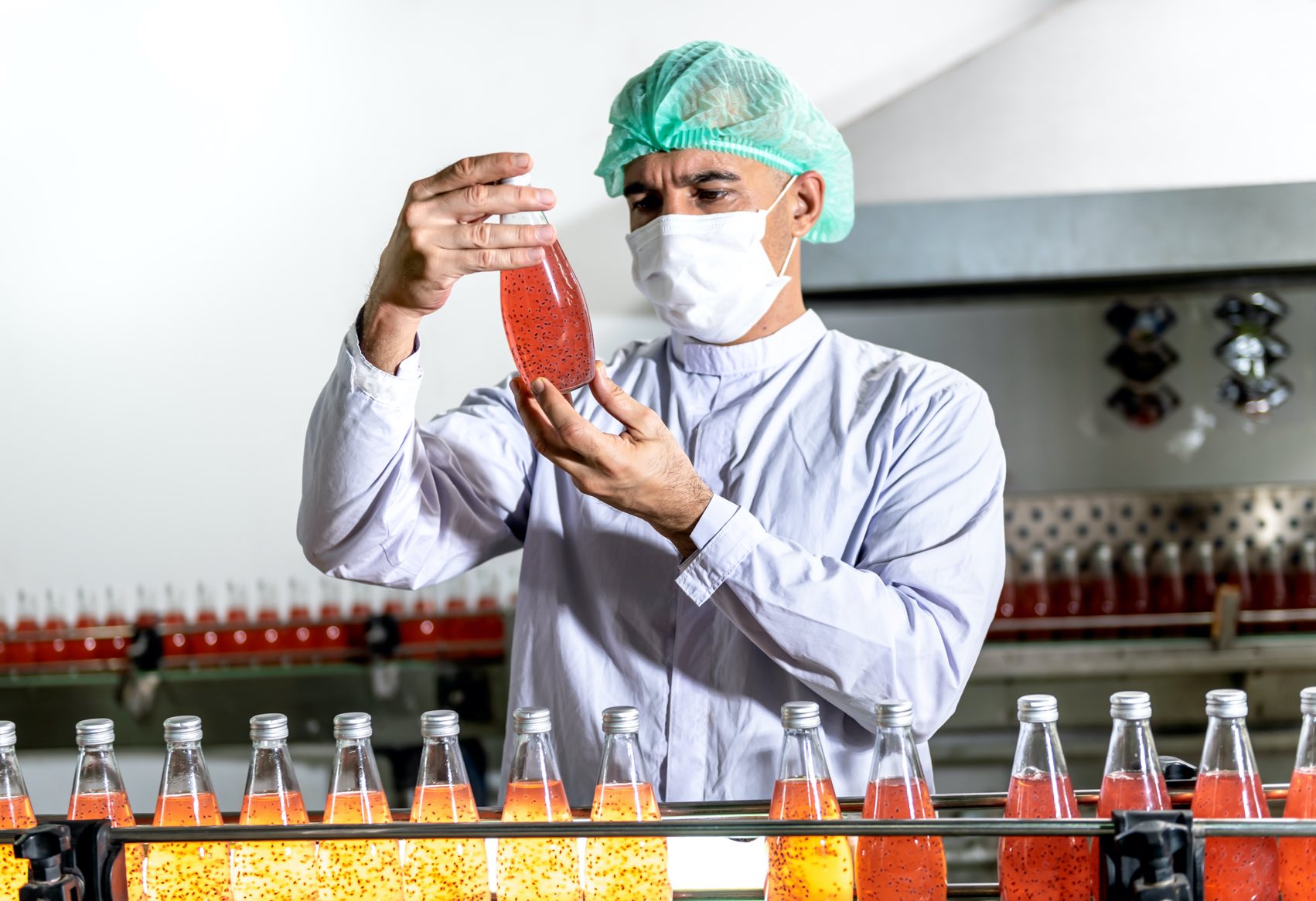 worker checking quality of soft drinks